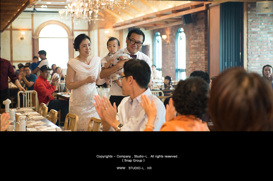 돌상 앞에서 케이크를 자르는 돌잔치 당일 가족사진