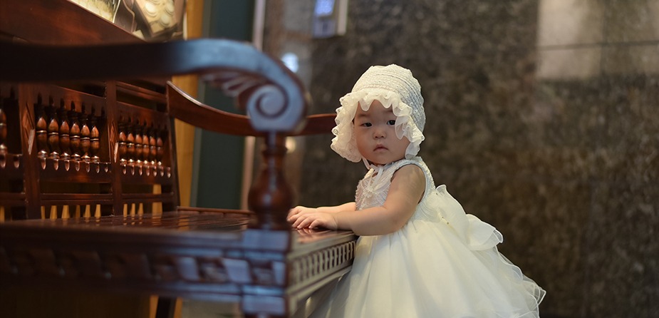 실내 고가구 앞에서 손을 짚고 카메라를 응시하는 아이