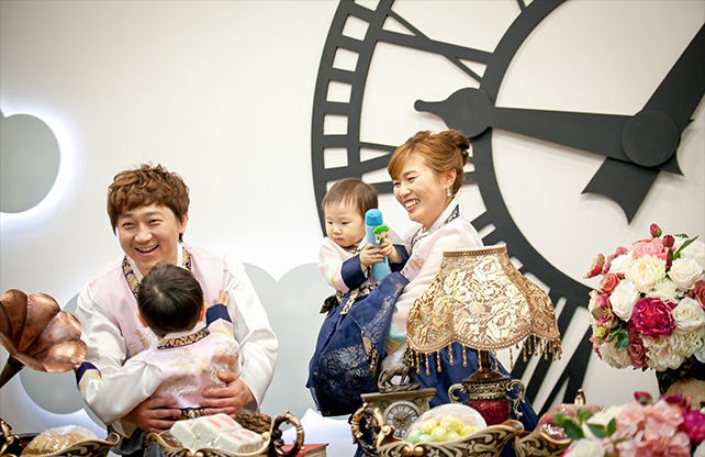 돌잔치 돌잡이 — 4인 가족, 부모·오빠·아기 한복 차림으로 돌잡이 상 앞에서