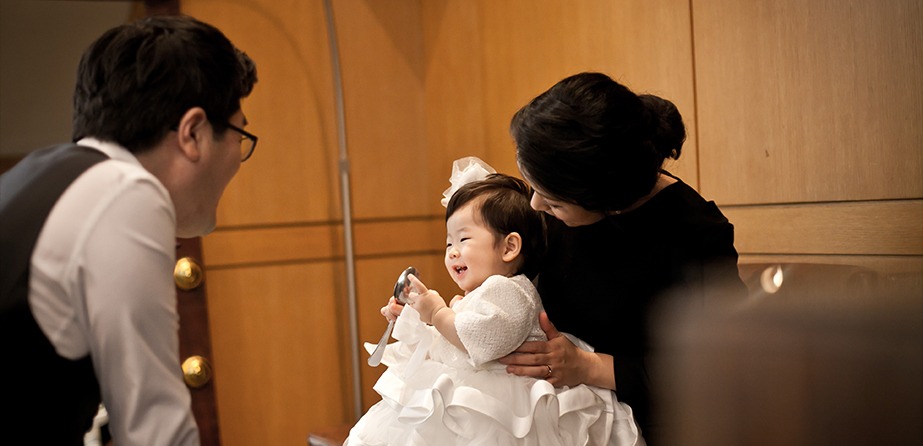 행사 중 마이크 잡고 웃는 승아 — 엄마 품에서 환하게 웃는 장면