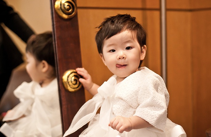 조명 거울 옆 승아 단독 — 혀 내밀고 카메라 보는 표정