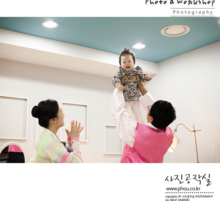 실내 홀에서 가윤이 번쩍 — 할머니와 부모, 파란 천장 배경